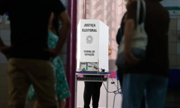 Foto mostra fila de eleitores em seção de votação