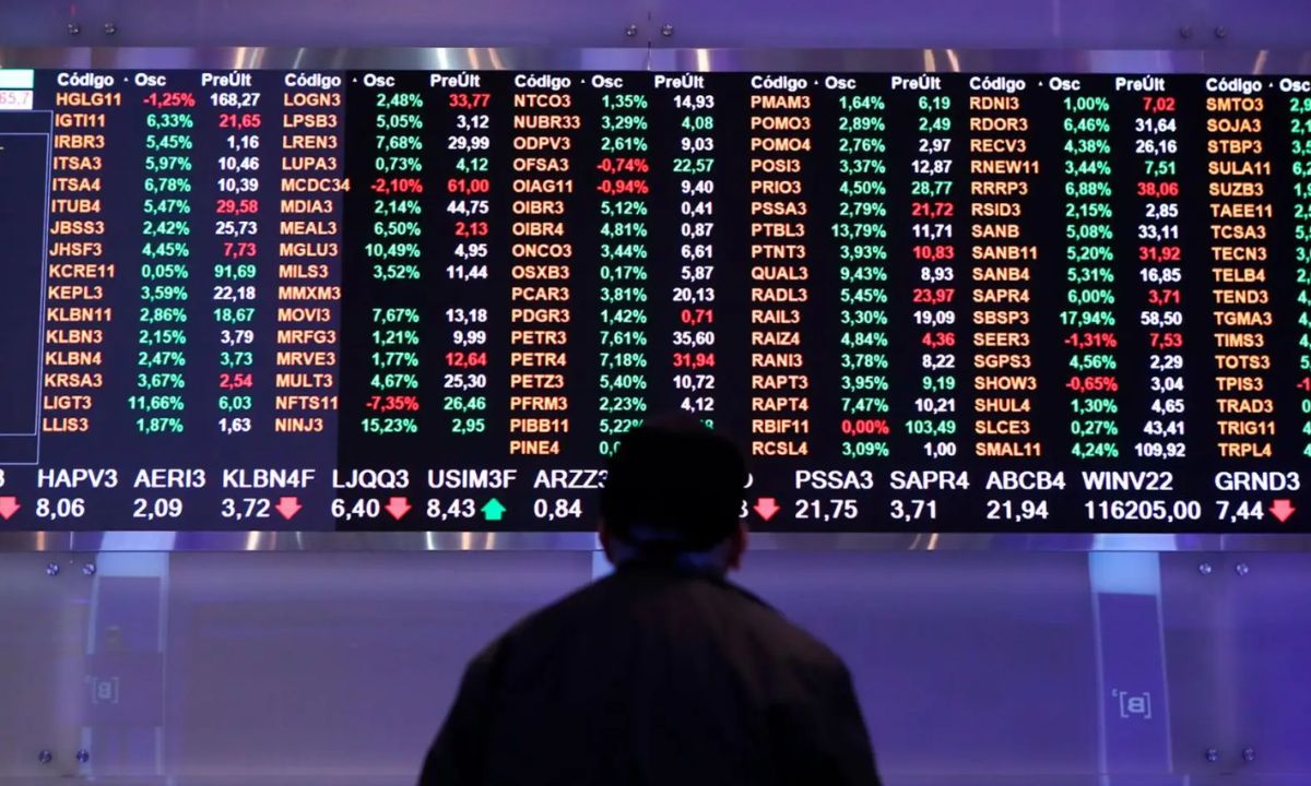 Homem acompanha painel com dados de ações