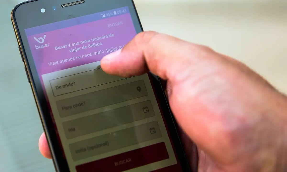 Homem usa aplicativo da Buser no celular