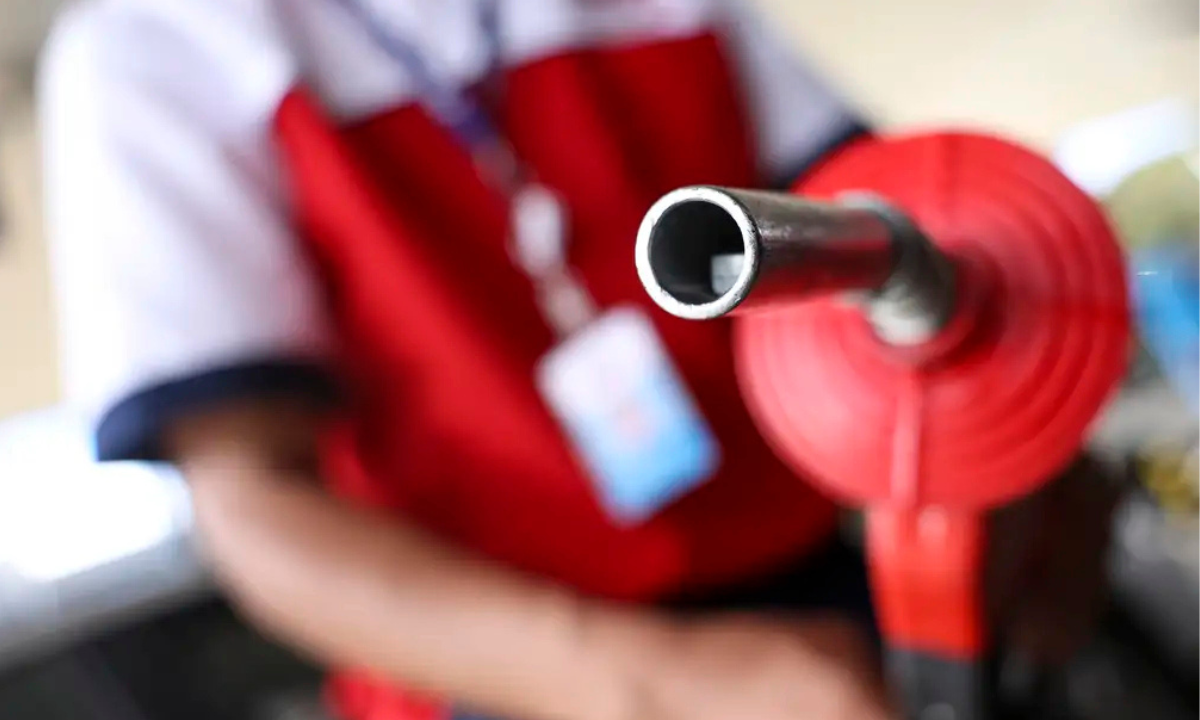 Frentista segura bico de abastecimento