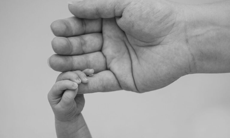 Mãe segura a mão de filho