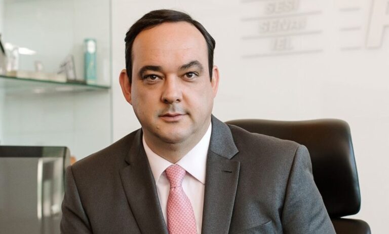 Flávio Roscoe de terno preto e gravata rosa