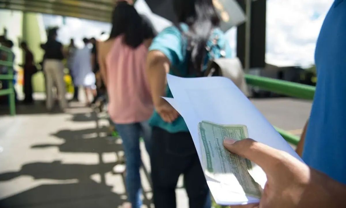 Foto mostra pessoas em uma fila