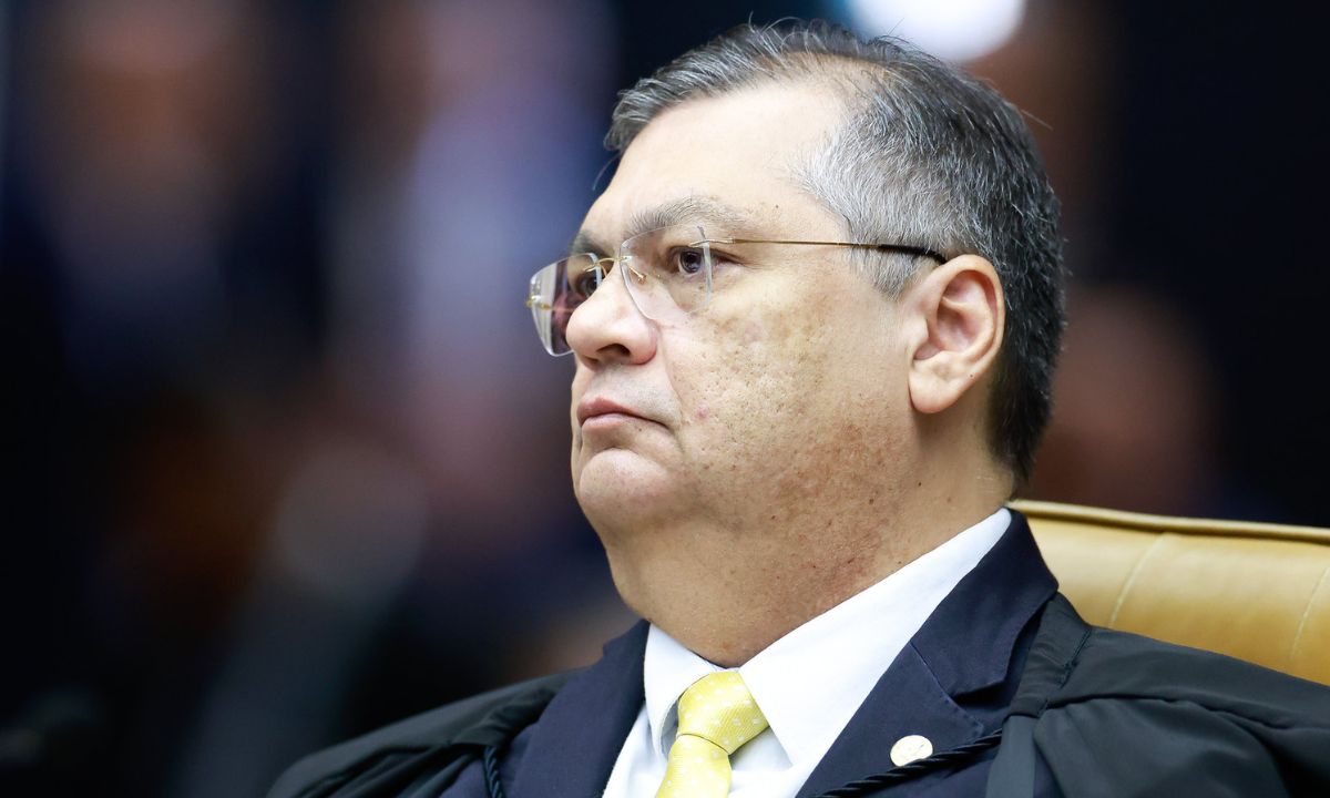 Flávio Dino de toga e gravata amarela, de perfil, no STF