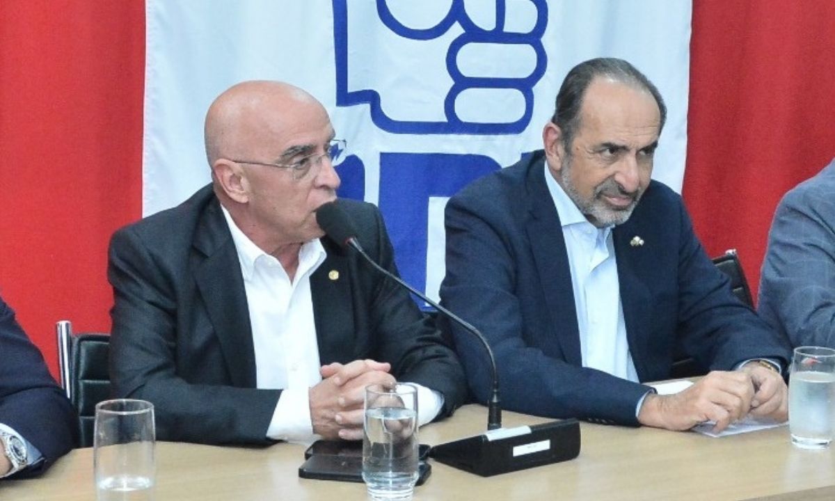 Mário Heringer e Alexandre Kalil, ambos de terno, com bandeira do PDT ao fundo