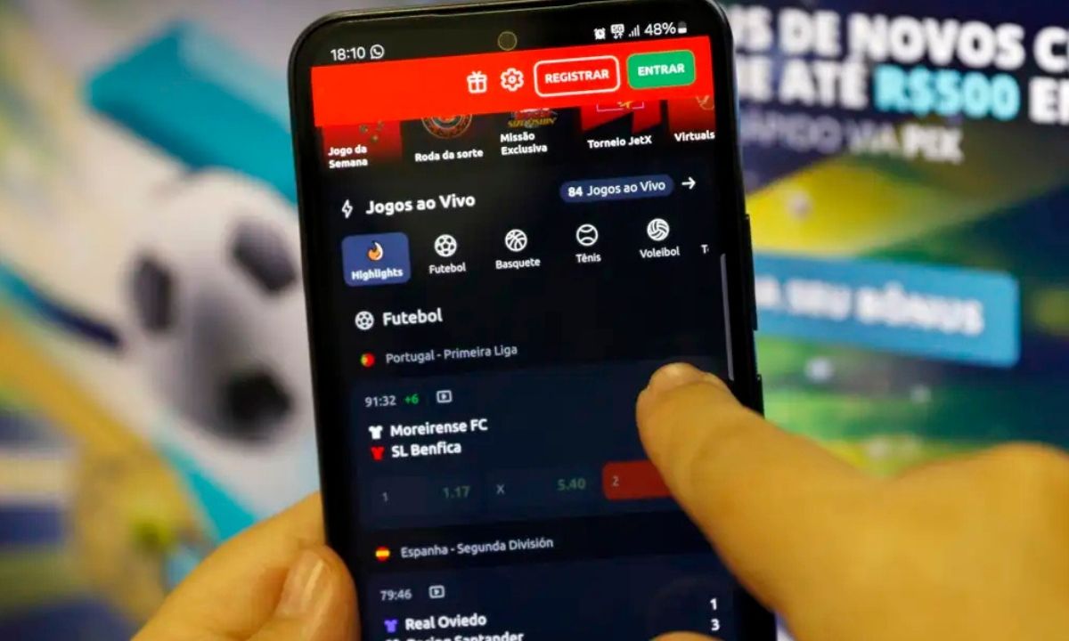 Pessoa mexendo no celular, vendo um aplicativo de bet