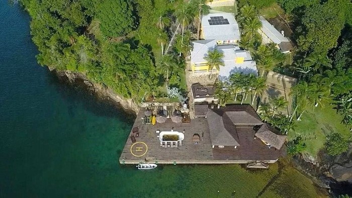 Mansão avaliada em R$ 10 milhões e situada na Ilha Comprida, em Angra dos Reis (RJ). O imóvel tem 11 suítes, praia privativa, cachoeira, piscina, quadra de tênis e heliponto. Foto: Reprodução