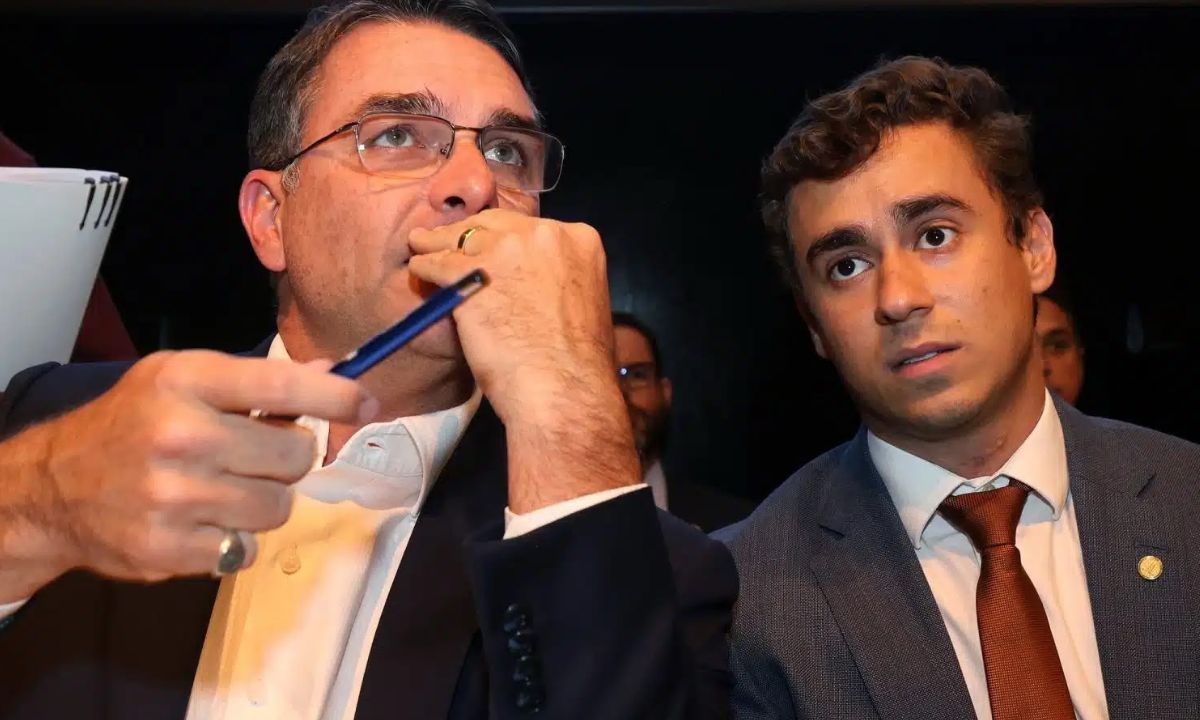 Flávio Bolsonaro e Nikolas Ferreira, lado a lado, ambos de terno
