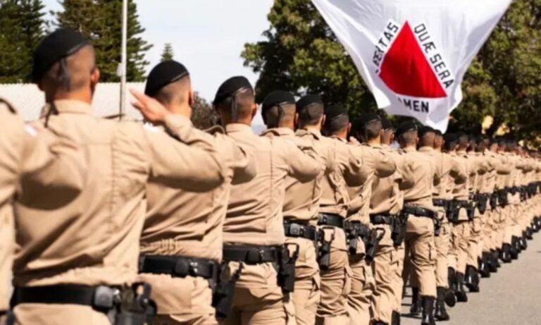 Militares perfilados com bandeira de Minas Gerais ao fundo