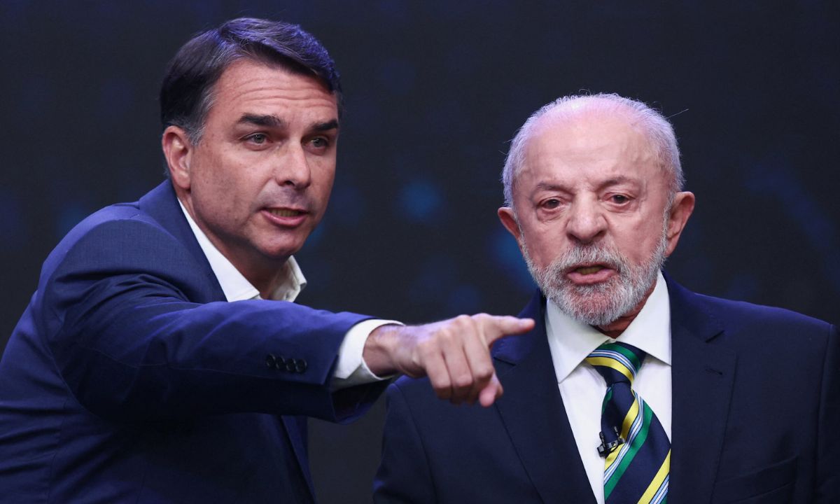 Flávio Bolsonaro (PL) aponta enquanto Lula (PT) responde, no debate da Band, em São Paulo, no domingo (18). Foto: