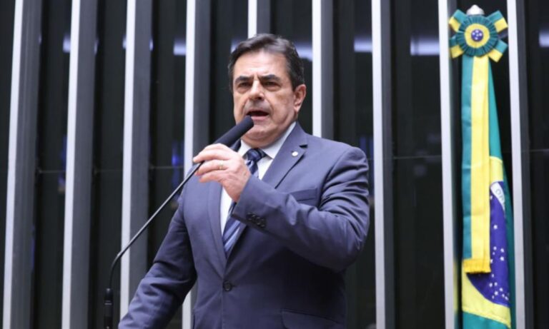Domingos Sávio falando ao microfone de terno