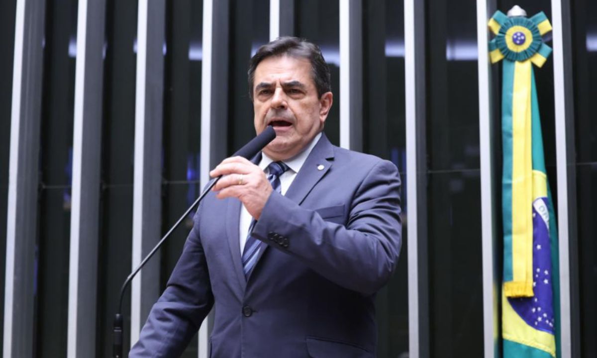 Domingos Sávio falando ao microfone de terno