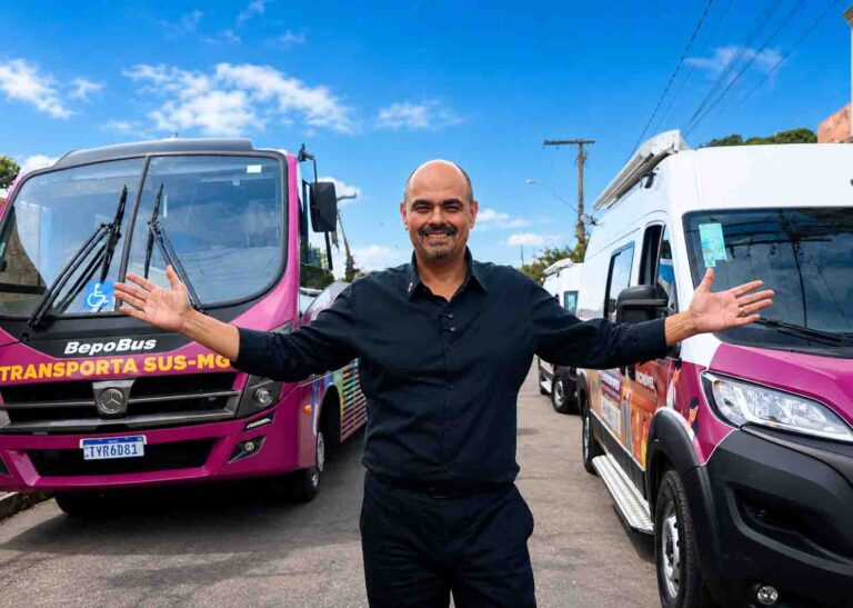 Governador Mateus Simões de braços abertos entre veículos do programa Transporta SUS-MG.
